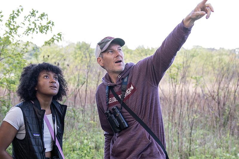 Dan Small (left) points out a bird to a Washington College student during a bird walk.
